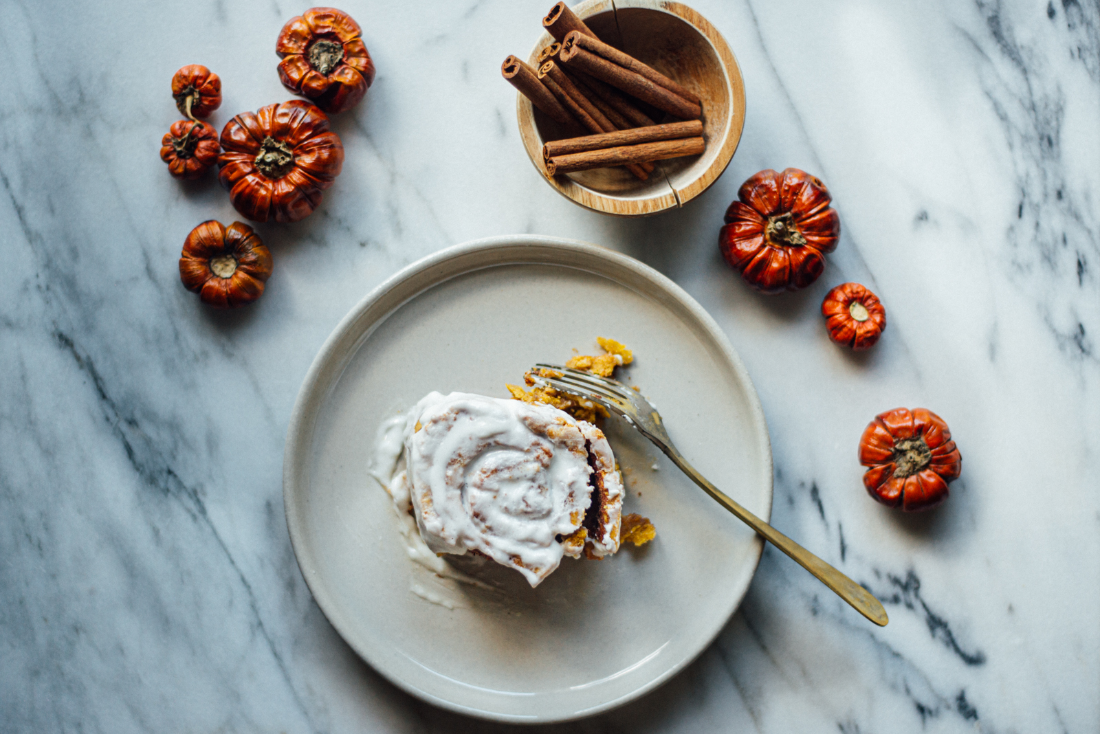 cream cheese frosting slathered on gluten-free pumpkin cinnamon roll