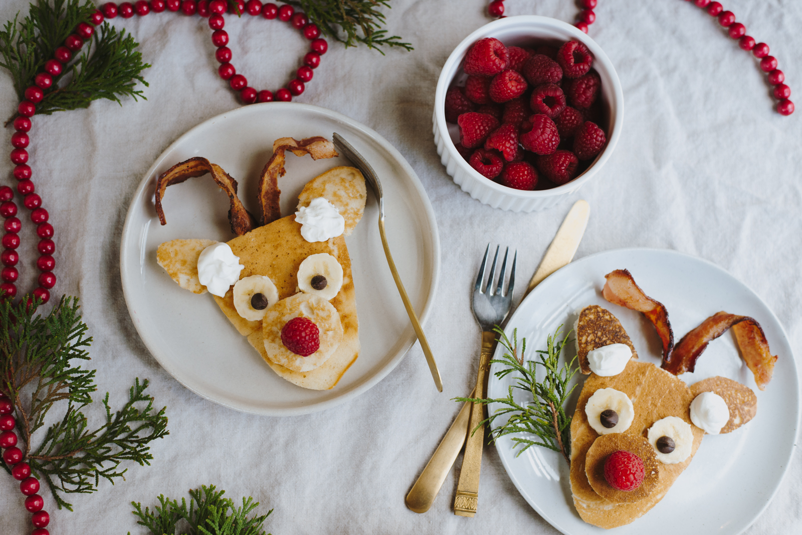 reindeer pancakes with bacon horns on linen tablecloth with raspberries